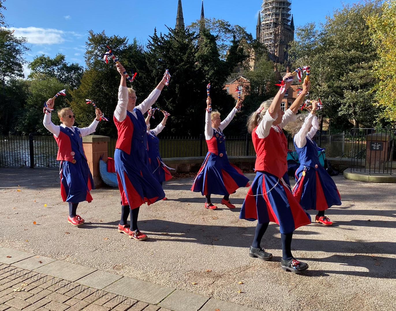 dancers with lake, trees and cathedral as a backdrop